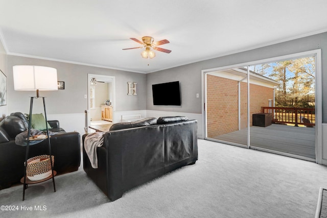 living room with carpet floors, ceiling fan, and ornamental molding