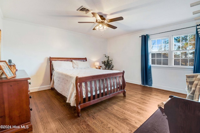 bedroom featuring dark hardwood / wood-style floors, ceiling fan, and crown molding