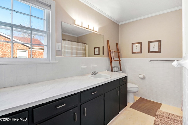 bathroom with vanity, tile patterned flooring, toilet, ornamental molding, and tile walls