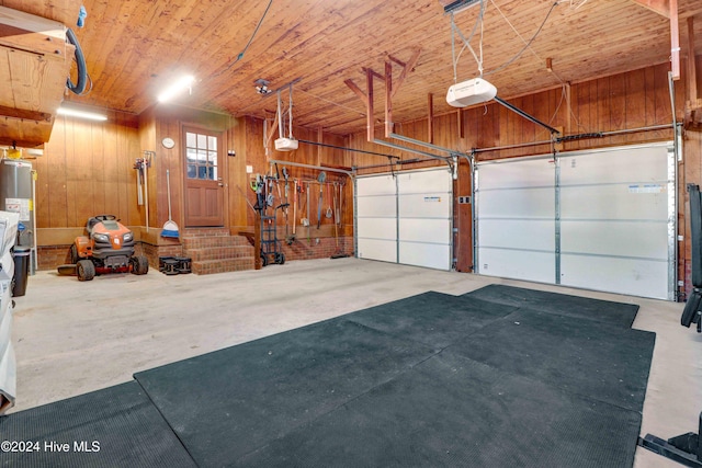 garage featuring wood walls, wood ceiling, a garage door opener, and water heater