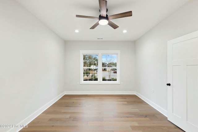 spare room with ceiling fan and light wood-type flooring