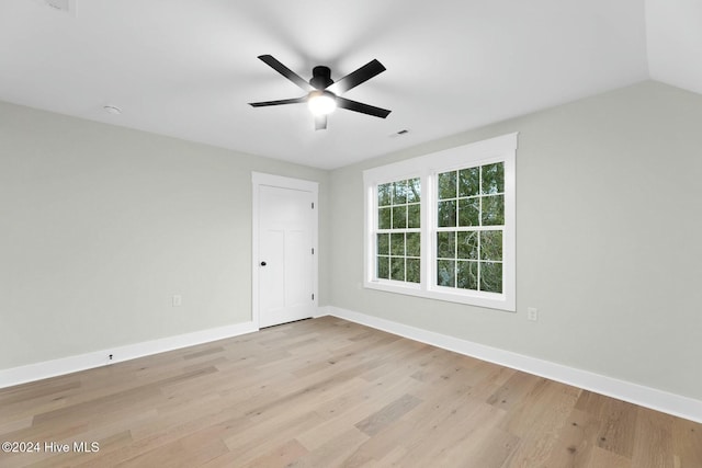 unfurnished room with ceiling fan, light hardwood / wood-style floors, and vaulted ceiling