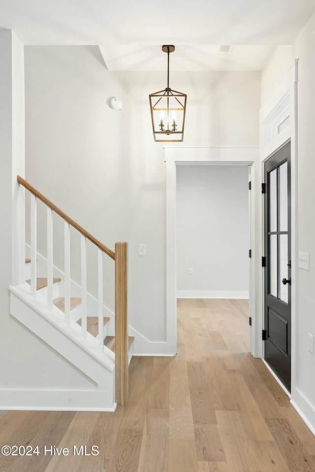 entrance foyer featuring light wood-type flooring and a notable chandelier