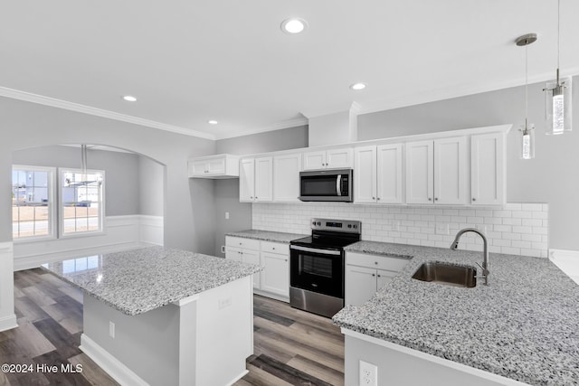 kitchen featuring white cabinetry, sink, hanging light fixtures, kitchen peninsula, and appliances with stainless steel finishes