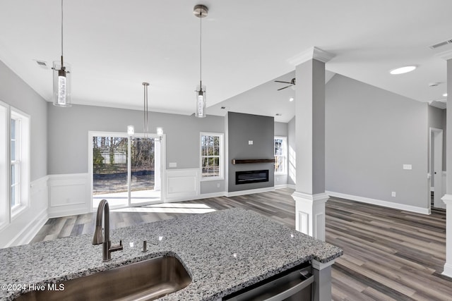 kitchen with light stone countertops, sink, ceiling fan, dark wood-type flooring, and stainless steel dishwasher