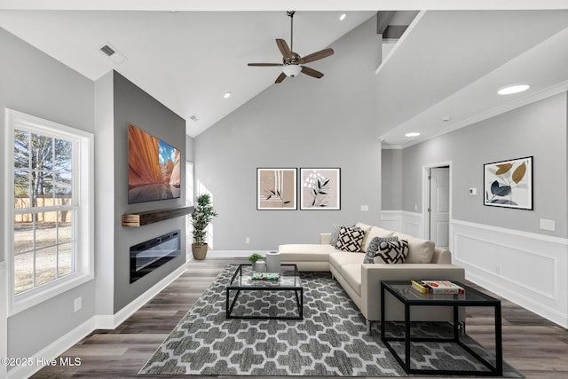 living room featuring ceiling fan, a wealth of natural light, dark hardwood / wood-style floors, and high vaulted ceiling