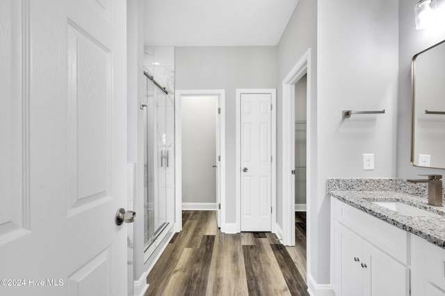 bathroom featuring hardwood / wood-style flooring, vanity, and an enclosed shower