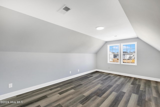 additional living space with dark wood-type flooring and lofted ceiling