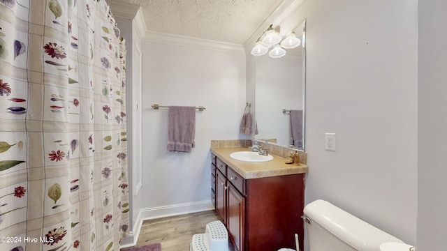 bathroom with vanity, hardwood / wood-style flooring, toilet, ornamental molding, and a textured ceiling