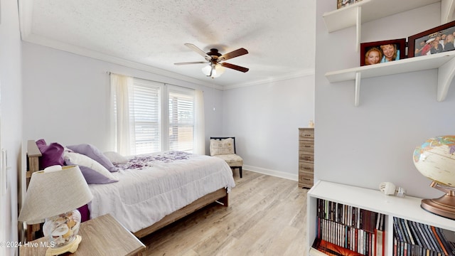 bedroom featuring a textured ceiling, light wood-type flooring, ceiling fan, and crown molding