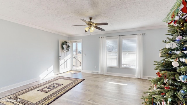 interior space featuring crown molding, hardwood / wood-style floors, ceiling fan, and a textured ceiling