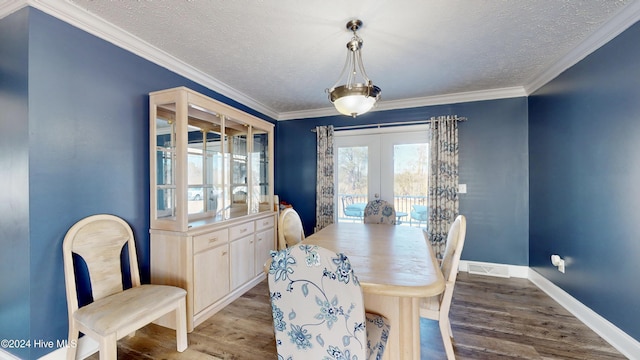 dining area featuring hardwood / wood-style floors, a textured ceiling, crown molding, and french doors