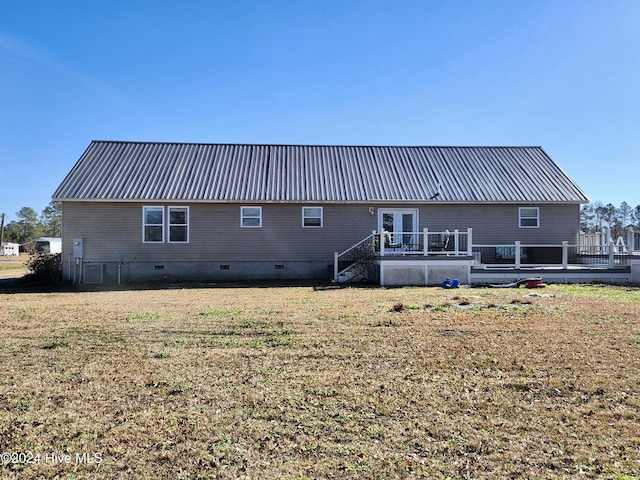 back of property with a lawn and a wooden deck