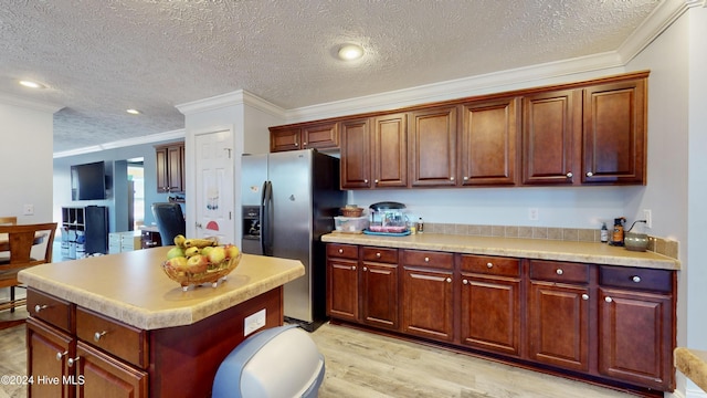 kitchen with a textured ceiling, crown molding, light hardwood / wood-style floors, and stainless steel refrigerator with ice dispenser