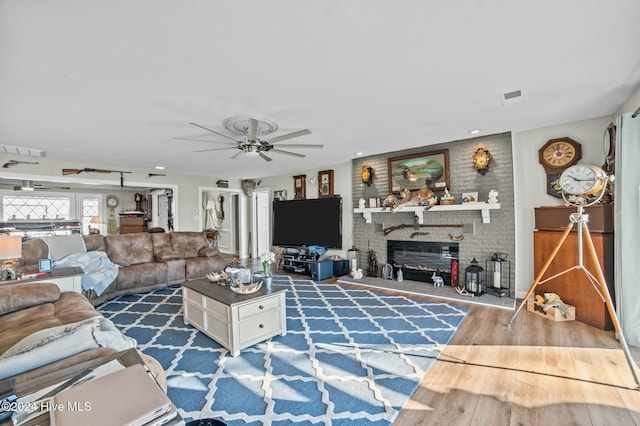 living room featuring ceiling fan and hardwood / wood-style floors