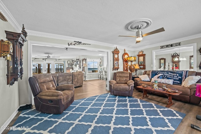 living room with a textured ceiling, hardwood / wood-style flooring, ceiling fan, and ornamental molding