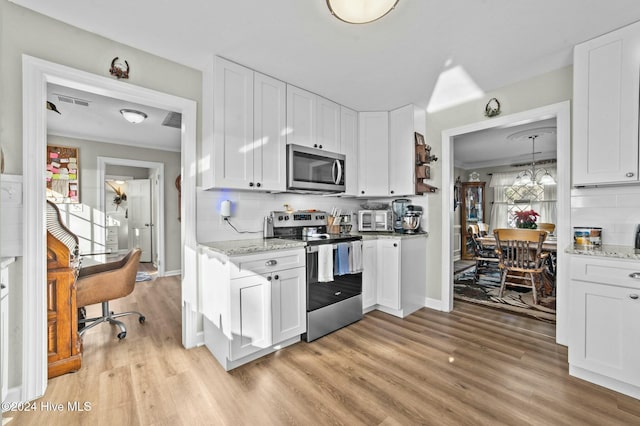 kitchen with white cabinetry, appliances with stainless steel finishes, and tasteful backsplash