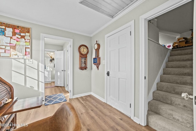 entryway with ornamental molding and light wood-type flooring