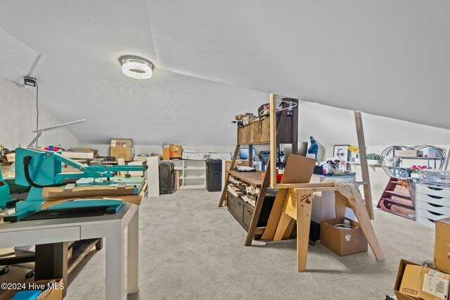 carpeted home office with vaulted ceiling