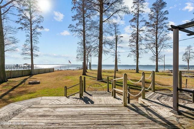 wooden deck with a water view and a yard