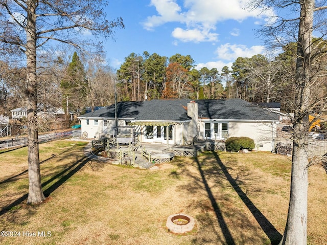 back of house featuring a wooden deck, a yard, and an outdoor fire pit