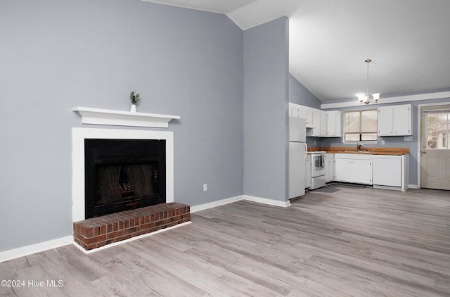 kitchen featuring a brick fireplace, white appliances, light hardwood / wood-style flooring, white cabinetry, and lofted ceiling