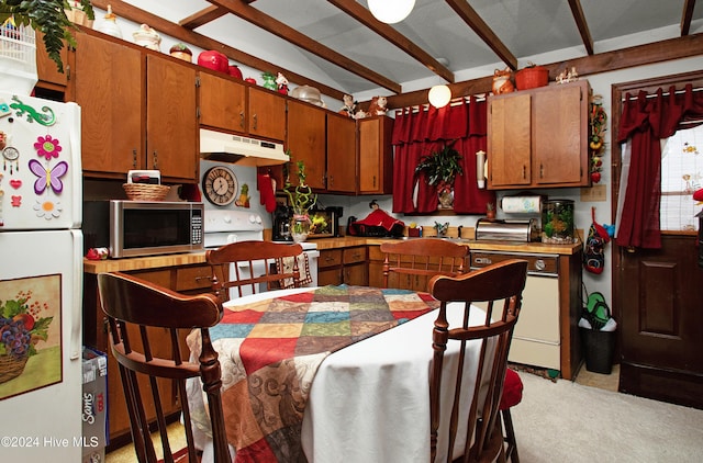 kitchen with light colored carpet, white appliances, and vaulted ceiling