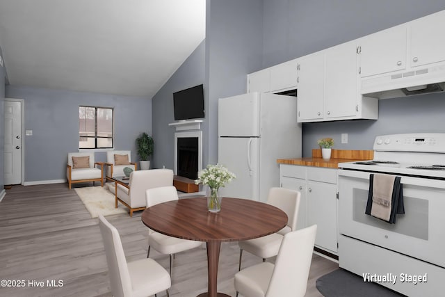 kitchen featuring light hardwood / wood-style flooring, white cabinets, white appliances, and high vaulted ceiling