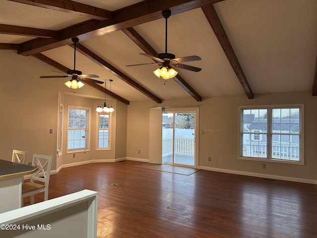 empty room featuring vaulted ceiling with beams, ceiling fan with notable chandelier, and dark wood-type flooring