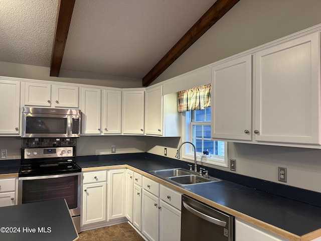 kitchen with lofted ceiling with beams, white cabinetry, sink, and appliances with stainless steel finishes