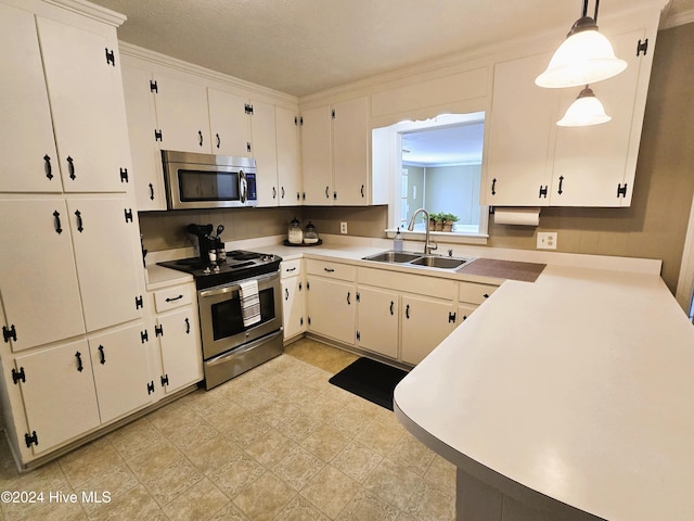 kitchen with sink, white cabinets, stainless steel appliances, and decorative light fixtures