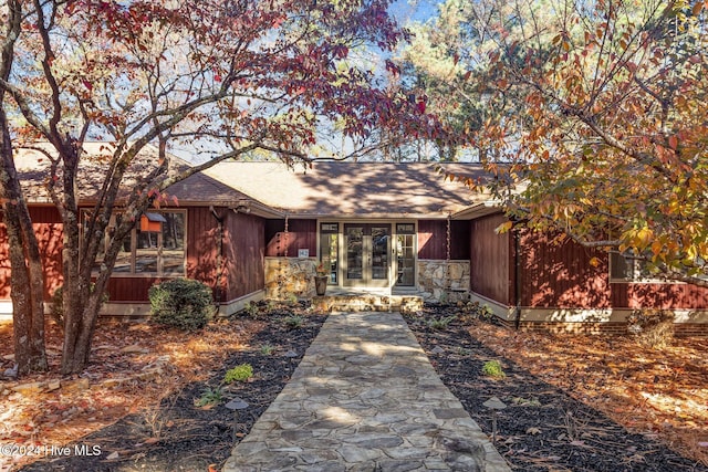 view of front of property featuring french doors and a shingled roof