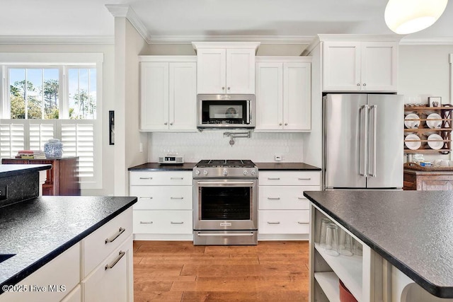 kitchen featuring backsplash, appliances with stainless steel finishes, crown molding, white cabinets, and light wood-type flooring