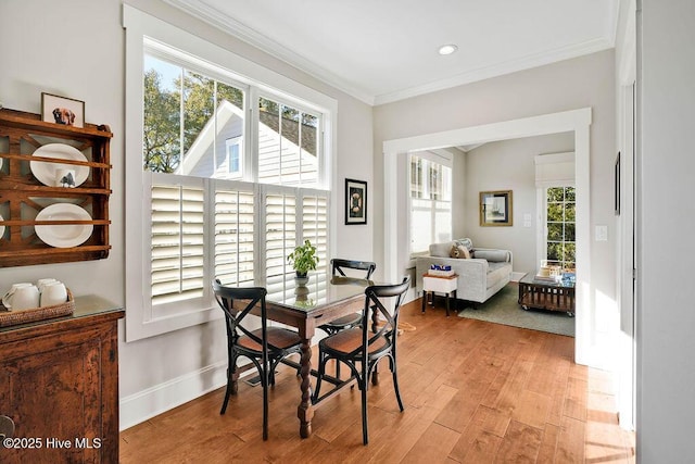 dining room with light hardwood / wood-style flooring and ornamental molding