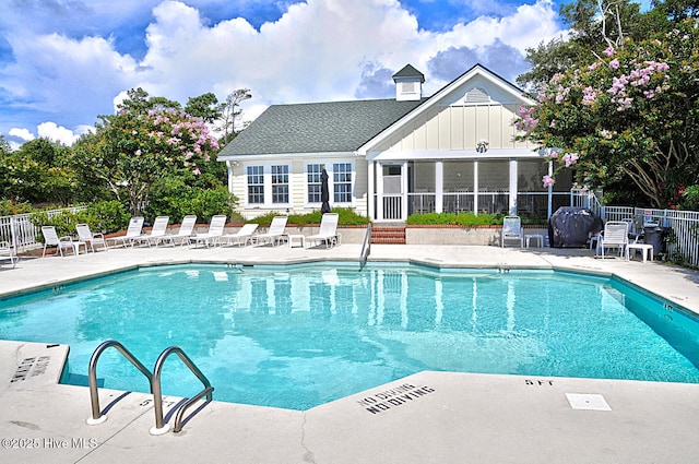 view of swimming pool featuring a patio area and a sunroom