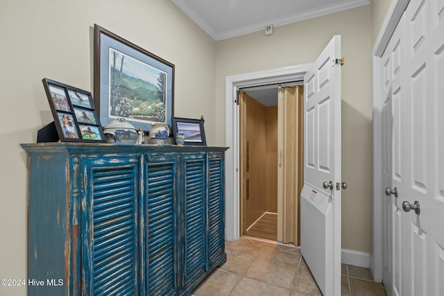 hallway featuring light tile patterned flooring and ornamental molding