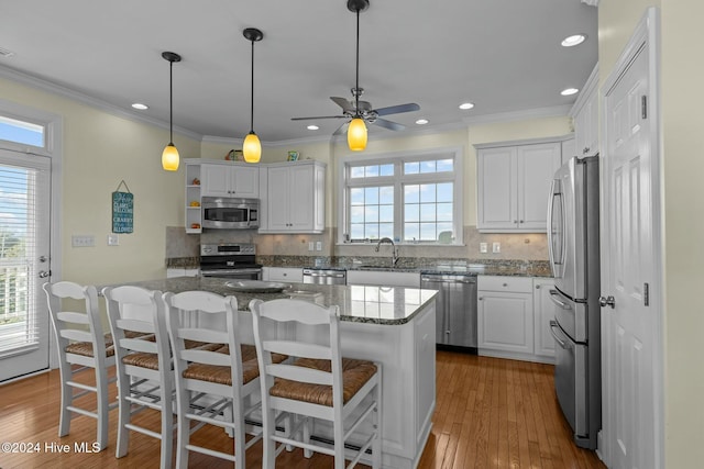 kitchen featuring backsplash, white cabinets, sink, stone countertops, and stainless steel appliances