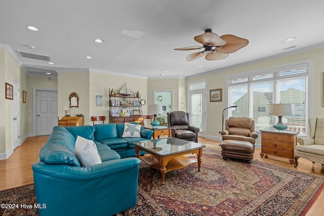 living room with ceiling fan, light wood-type flooring, and crown molding