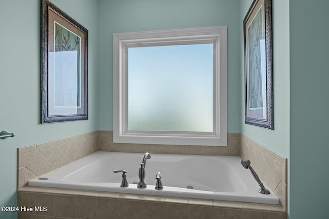 bathroom featuring plenty of natural light and tiled bath