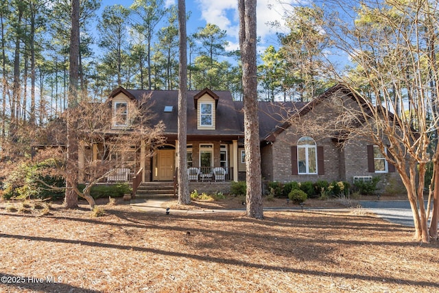 view of front facade featuring covered porch and brick siding