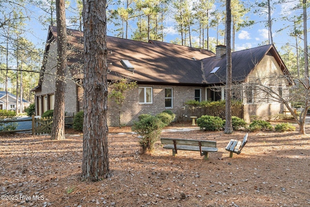 exterior space with a chimney and brick siding