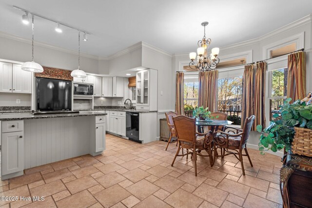 7 Brinyan Ct, Pinehurst, NC 28374 - kitchen featuring black appliances, stone tile floors, a chandelier, rail lighting, and white cabinetry