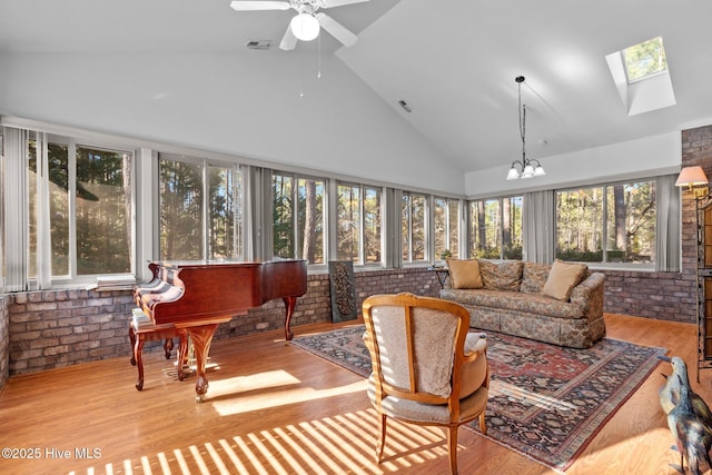 7 Brinyan Ct, Pinehurst, NC 28374 - sunroom featuring brick wall, a skylight, high vaulted ceiling, wood finished floors, and a chandelier