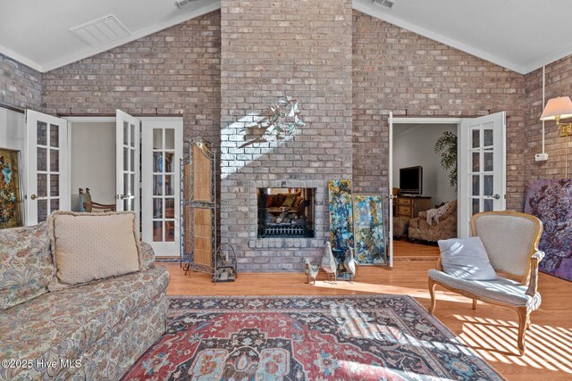 7 Brinyan Ct, Pinehurst, NC 28374 - living room with french doors, high vaulted ceiling, wood finished floors, and a brick fireplace