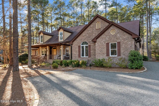 7 Brinyan Ct, Pinehurst, NC 28374 - view of front of home featuring covered porch, brick siding, and roof with shingles