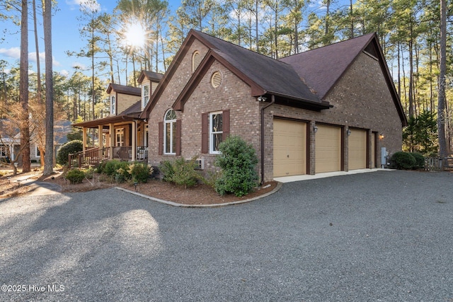 7 Brinyan Ct, Pinehurst, NC 28374 - view of home's exterior with brick siding, an attached garage, a porch, asphalt driveway, and roof with shingles