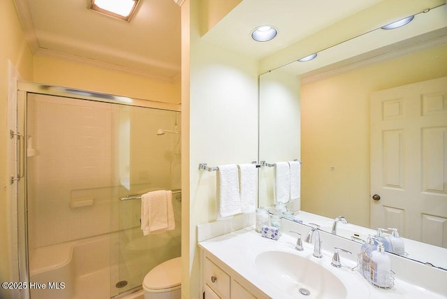 bathroom featuring toilet, a shower with door, vanity, and ornamental molding