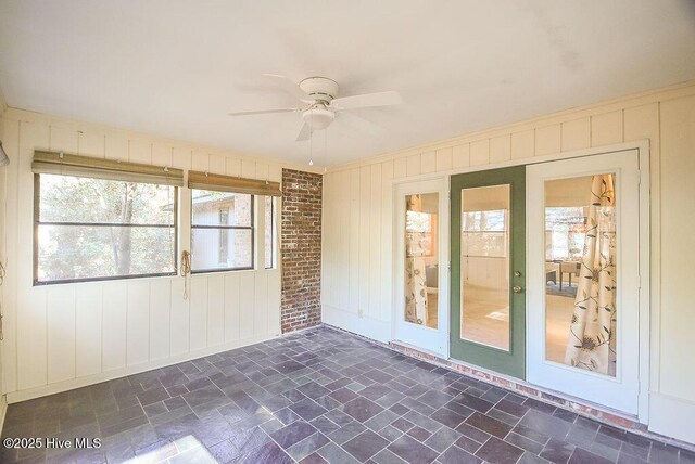 unfurnished sunroom with ceiling fan