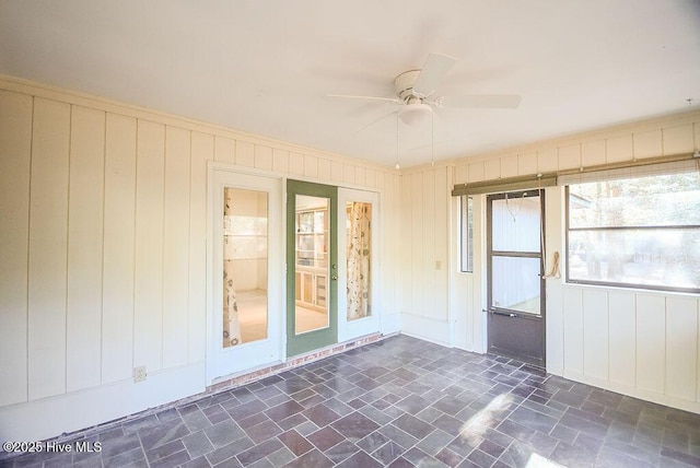 unfurnished sunroom featuring ceiling fan