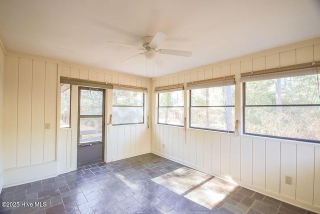 unfurnished sunroom featuring ceiling fan